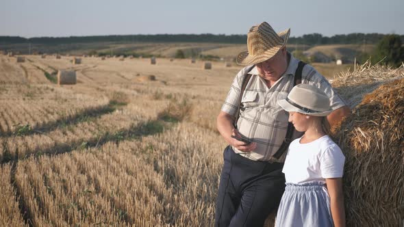 Little Girl with Grandfather in Field Haystacks, Grandfather Farmer Is Teaching