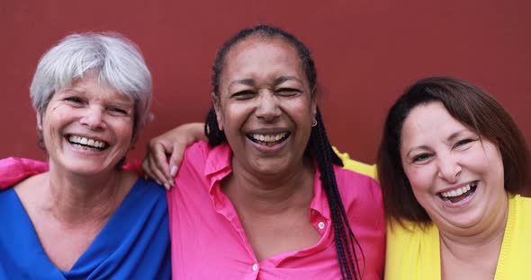 Multiracial mature female friends smiling on camera