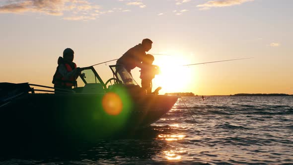 Children Are Fishing with Their Dad at Sunset