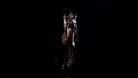 Gymnast Rotates on a Metal Structure Moon in a Vertical String