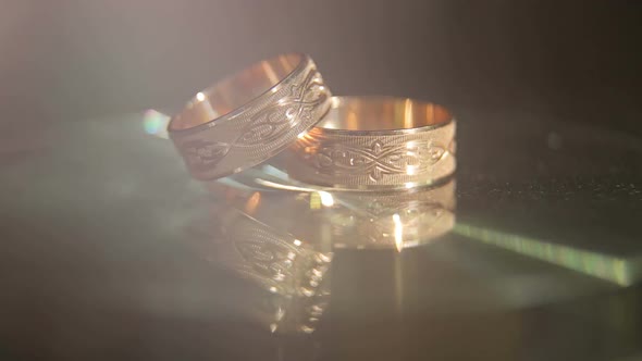 Closeup of Two Golden Wedding Rings on a Black