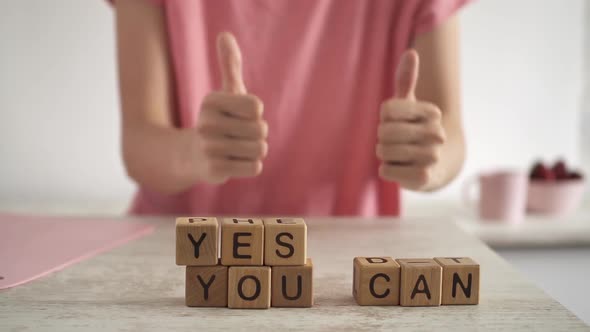 The Phrase Yes You Can Motivate To Success. The Young Woman Raised Her Thumbs In Front Of Her