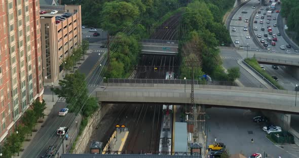 Aerial Following Shot of a Passing Train Near a Highway in New York