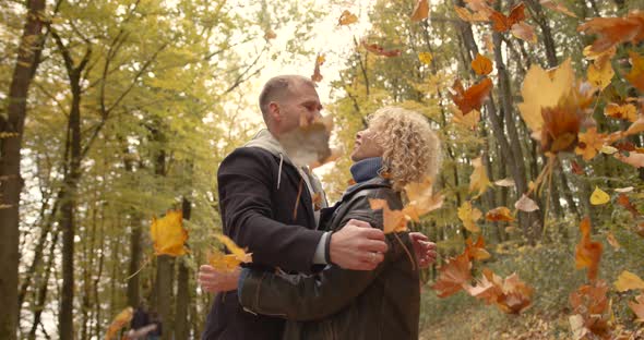 Couple Throwing Leaves in to Air in Autumn Park