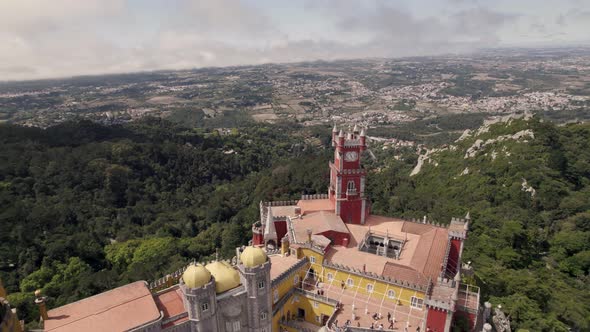 Aerial circular pan shot around the decorative clock tower of Pena palace in Sintra Portugal