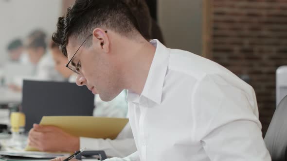 Bank Employee Works with Papers