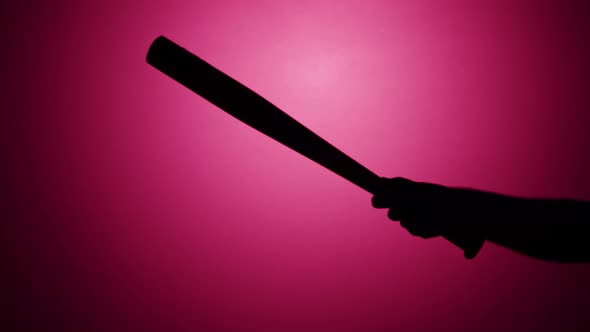 Man Holding Baseball Bat Closeup Shadow Silhouette of Hand with Weapon on Pink Neon Background Sport