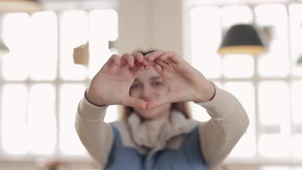 Pretty Brunette Making Heart Shape with Fingers