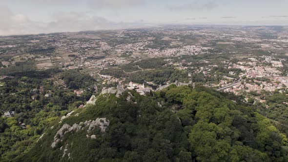 Cinematic dolly in overlooking at Castle of the Moors and reveals town palace in far distance.