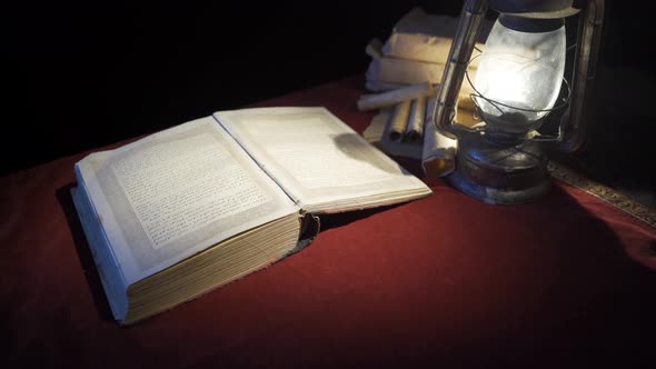 Historical book in the light of an old oil lamp.
