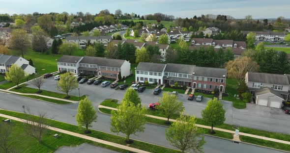 Homes in USA. Aerial establishing shot, turn to reveal spring sunset. Townhouse townhomes.