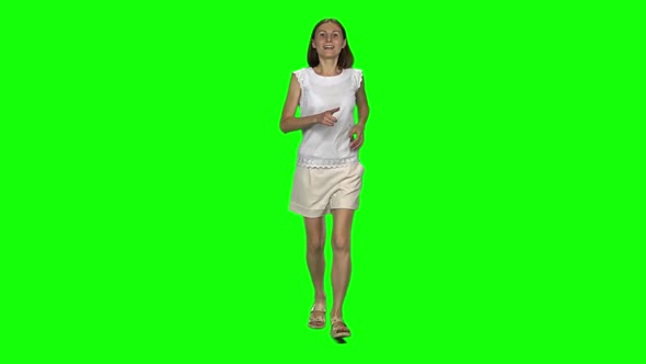 Young Woman with Brown Hair and Smooth Haircut Is Running and Waving Hand Stop on Green Screen. Slow
