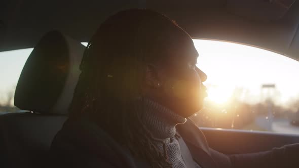 Portrait of Young African American Black Man Driving a Car During the Sunset
