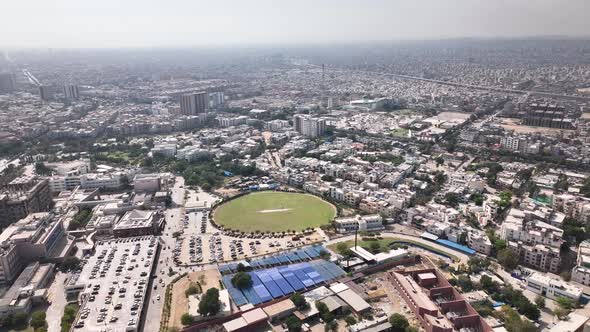 Aerial shot of Karachi city full of buildings and houses and cricket ground in the middle of the cit