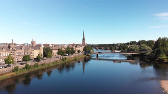 Drone descending above river Tay revealing beautiful reflection of St. Matthew's Church of Scotland.