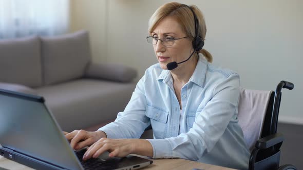 Call-Center Female Operator Working With Client Typing on Laptop, Disabled Woman