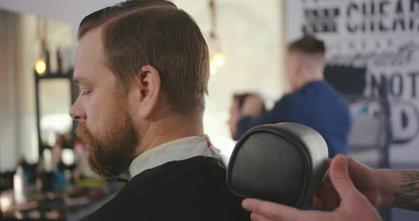 Stylish Hipster Man Sitting in Chair in Barber Shop