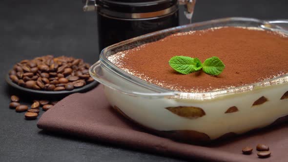 Tiramisu Dessert in Glass Baking Dish and Coffee Grinder Mill on Concrete Background