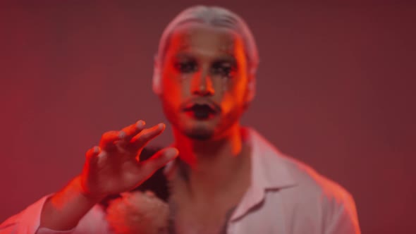 Man with Make-Up and White Hair Posing in Red Lighting