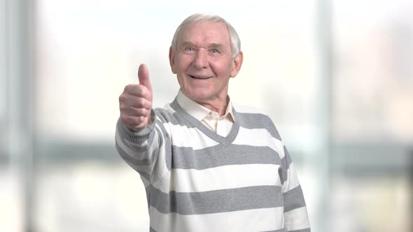 Cheerful Pensioner Gesturing Thumb Up.