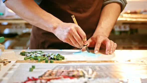 Male hands cutting a piece of glass in creative studio