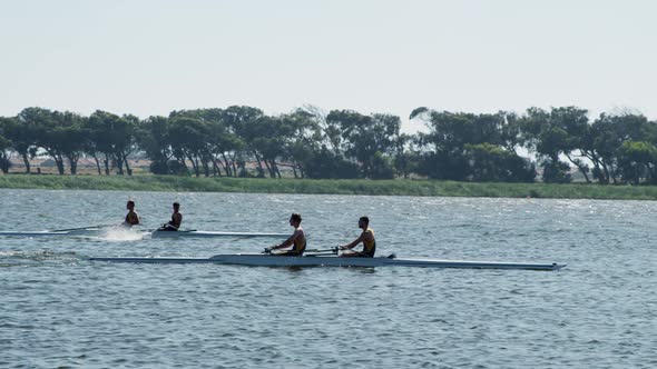 Male rowers team rowing on the lake