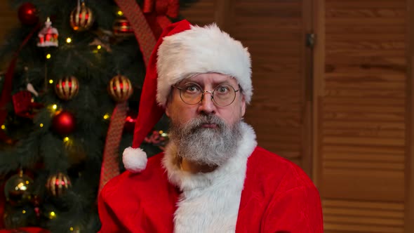 Portrait of Santa Claus Looking at Camera Listens Attentively and Makes a Gesture Ok