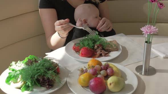 Mother with baby daughter having meal in cafe