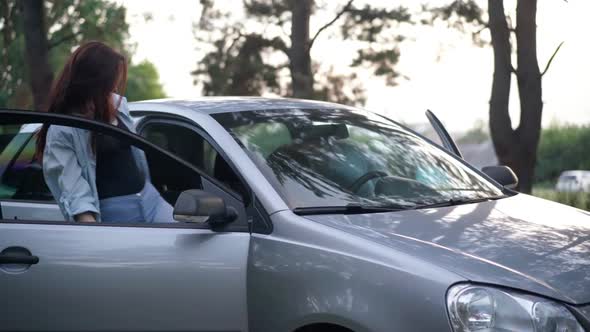 Happy Young Couple Getting in Car Closing Doors in Forest at Sunset