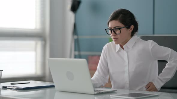 Indian Businesswoman having Back Pain while using Laptop in Office