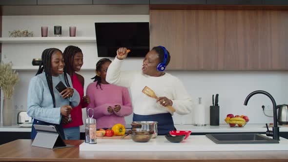 Surprised Teenage Girls Filming on Phone Dancing Mom in Kitchen