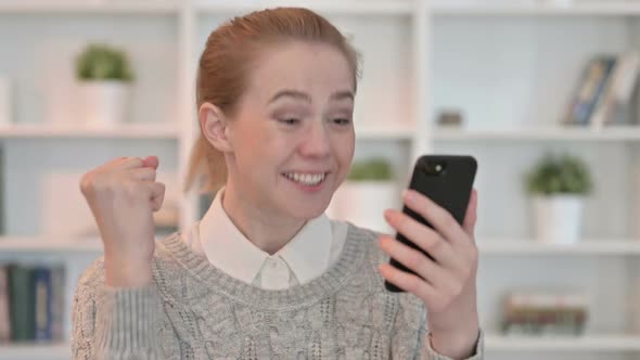 Portrait of Young Woman Celebrating Success on Smartphone