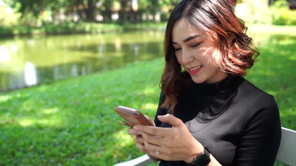 slow-motion of woman using smartphone in park