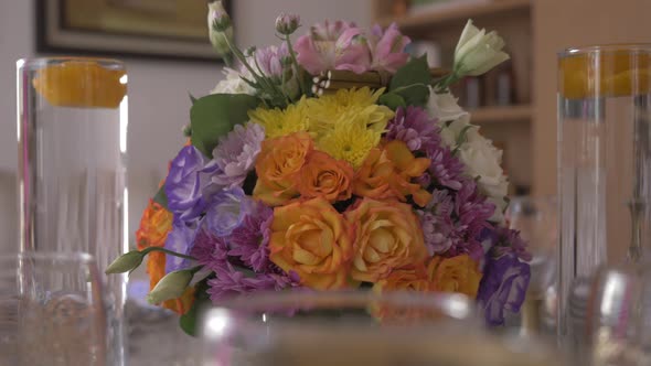 Rotating shot of flower basket bouquet of gerbera and roses with view of the hall in the background.