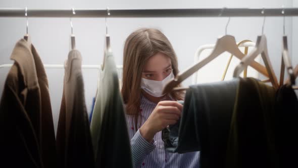 Woman with Covid Mask Shopping for Dress in Clothing Retail Store or Fashion Showroom