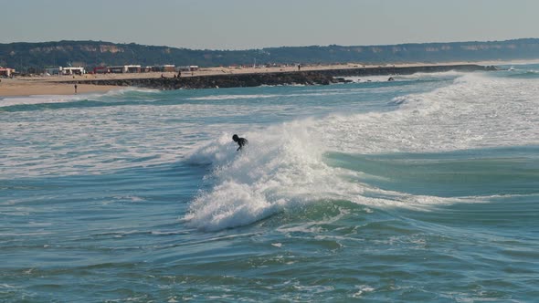 Surfer falling into the water while surfing near the Lisbon beach. 