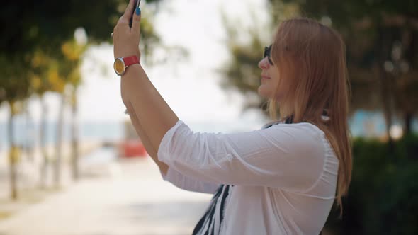 Woman making selfie when walking with baby outdoor