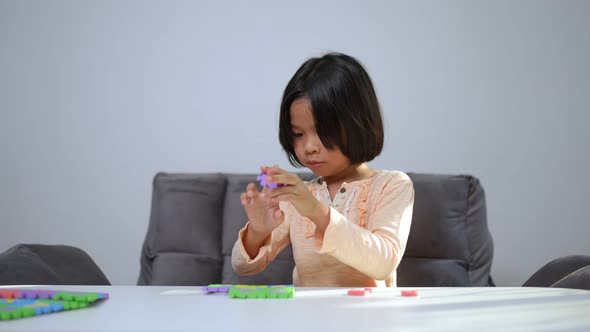 Cute Asian little girl playing with colorful toy ABC jigsaw, Kids play with educational toys at kind