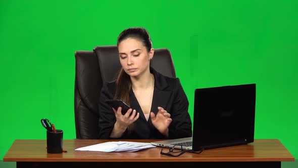 Girl Working on a Laptop Then Answers the Call By Mobile Phone. Green Screen. Slow Motion