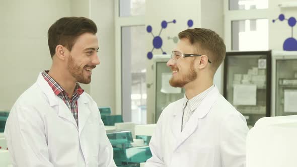Two Laboratory Technicians Communicate on Working Subjects