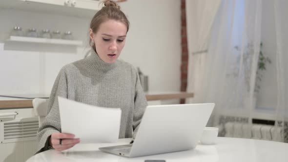 Young Woman Reading Documents and Reacting To Failure