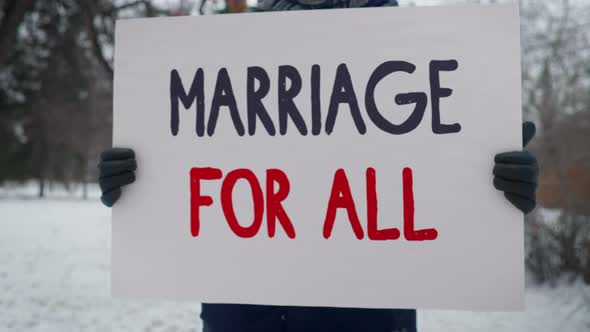 An activist is holding a banner Marriage For All in support of gay rights