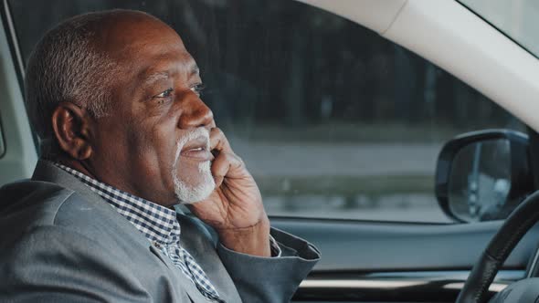 Mature Elderly African American Businessman Sitting in Car Answering Business Mobile Call Confirming