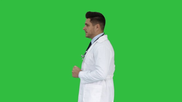 Walking male doctor passing by on a Green Screen, Chroma Key.