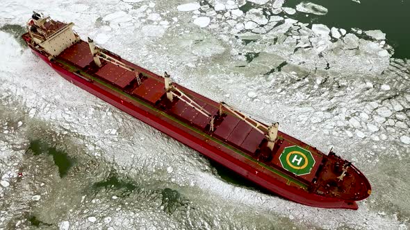 Aerial Above Epic Huge Steel Icebreaker Breaks Ice By Bow of Ship and Floats in Large Sea Ice Floes