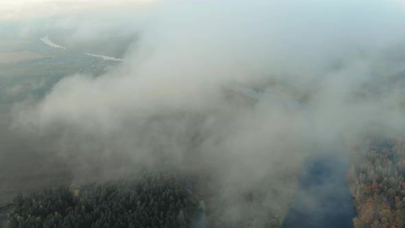 Low-lying Clouds Over an Evergreen Forest with a River. Fog Over the Jungle