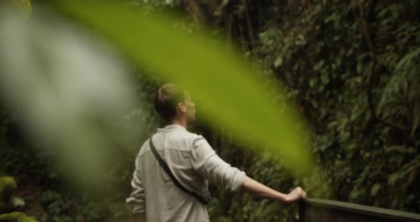 Hidden Back View of a Young Adult Male Looking Around in a Tropical Jungle