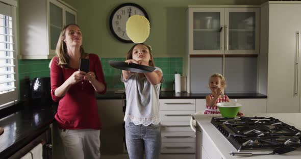 Mother and daughters cooking crepes together