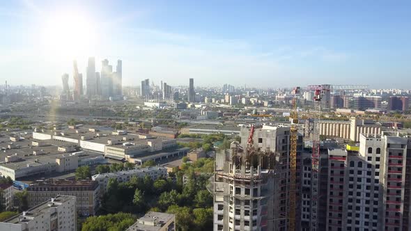 Top View of Residential High-rise Building Under Construction, High Cranes Against Background of