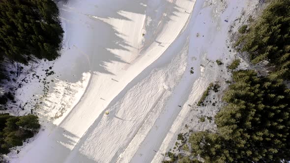 Drone flight over a group of people skiing in the ski resort during winter season